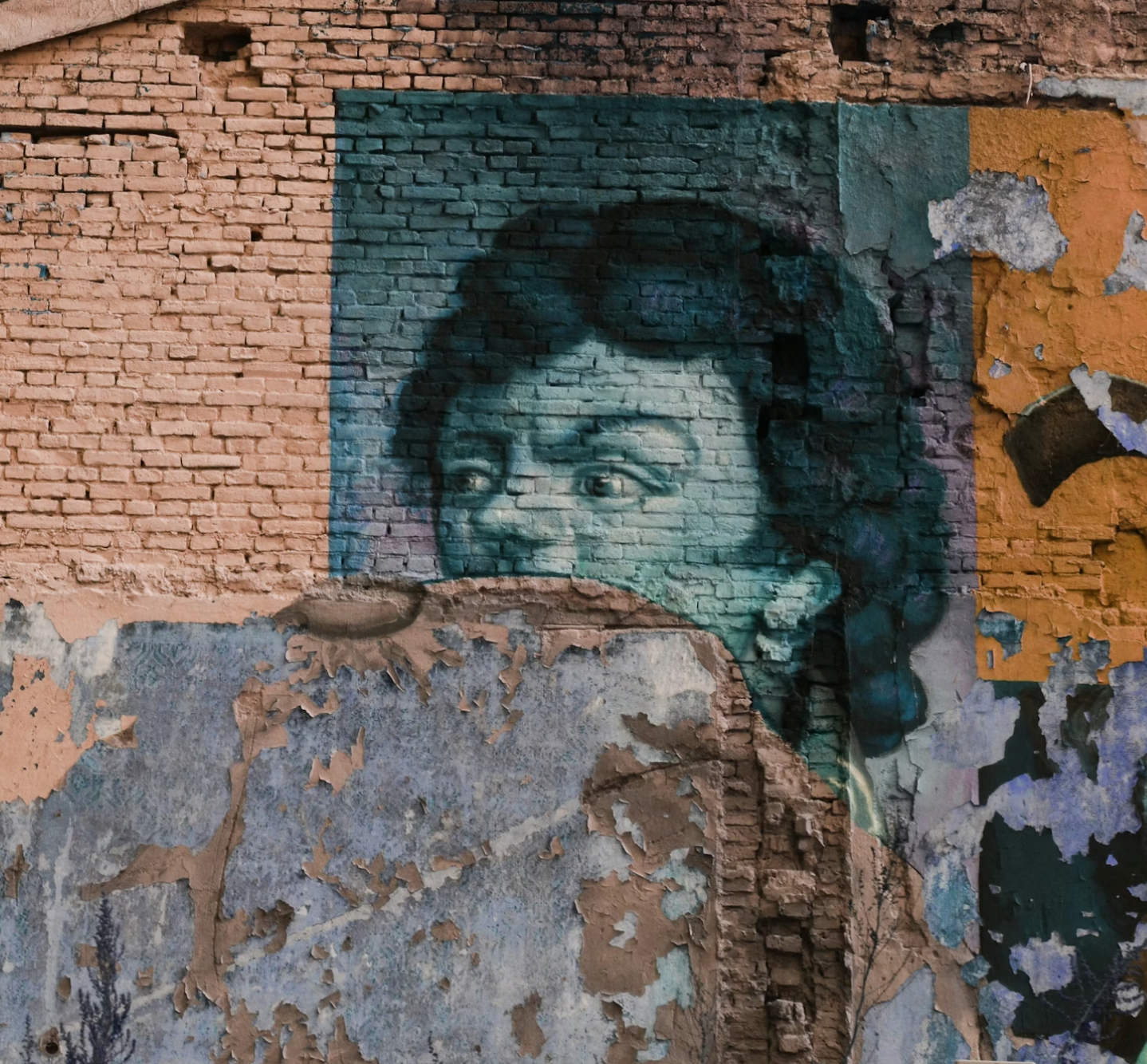 Afbladderende graffiti op een bakstenen muur